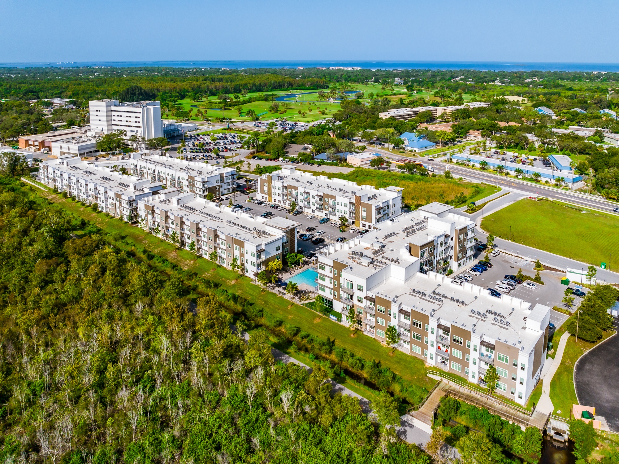 A large white building complex with a pool in the middle of it.